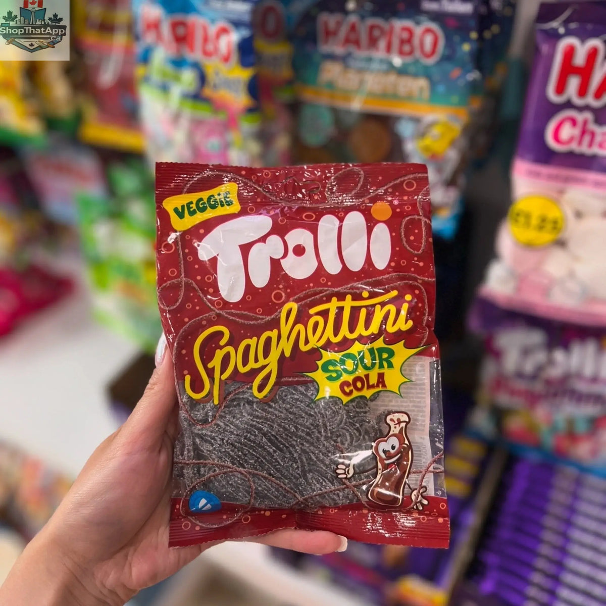 Colorful Trolli Spaghetti Sour Cola candy in a clear bag, with twisted spaghetti-like sour cola-flavored gummies.