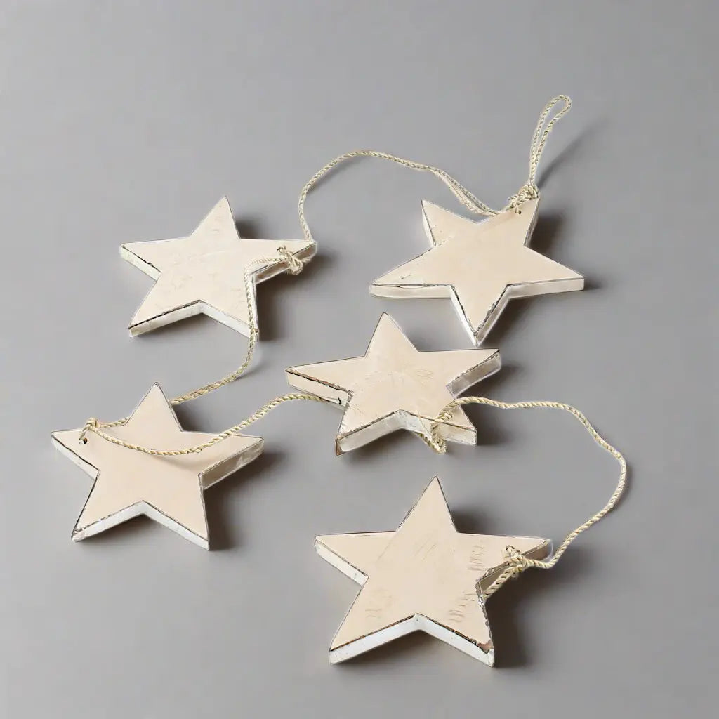 String of five hanging wooden star decor pieces from Suzie Blue Canada for home decoration, featuring rustic wooden star designs.