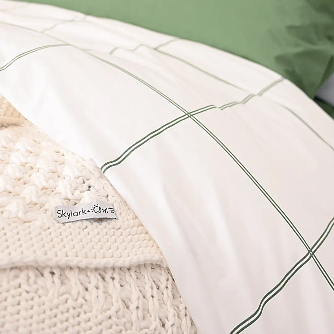 Luxurious organic percale sheet set from Skylark+Owl Canada, featuring crisp, breathable sheets in a cozy bedroom setting.