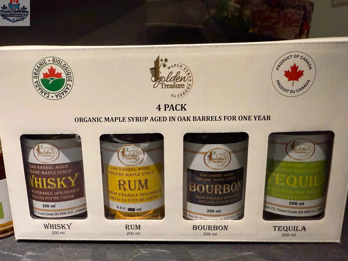 Four bottles of Golden Treasure Maple Syrup oak barrel aged maple syrup with front labels visible.