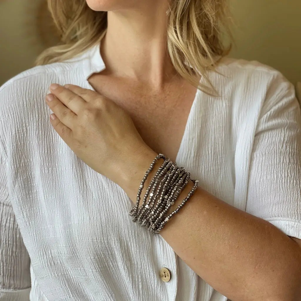 Multi strand stretch cuff bracelet by Suzie Blue Canada featuring layered, colorful elastic bands on a neutral background.