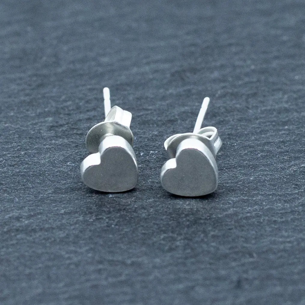 Small silver heart stud earrings with delicate plate design by Suzie Blue Canada, perfect for everyday wear.