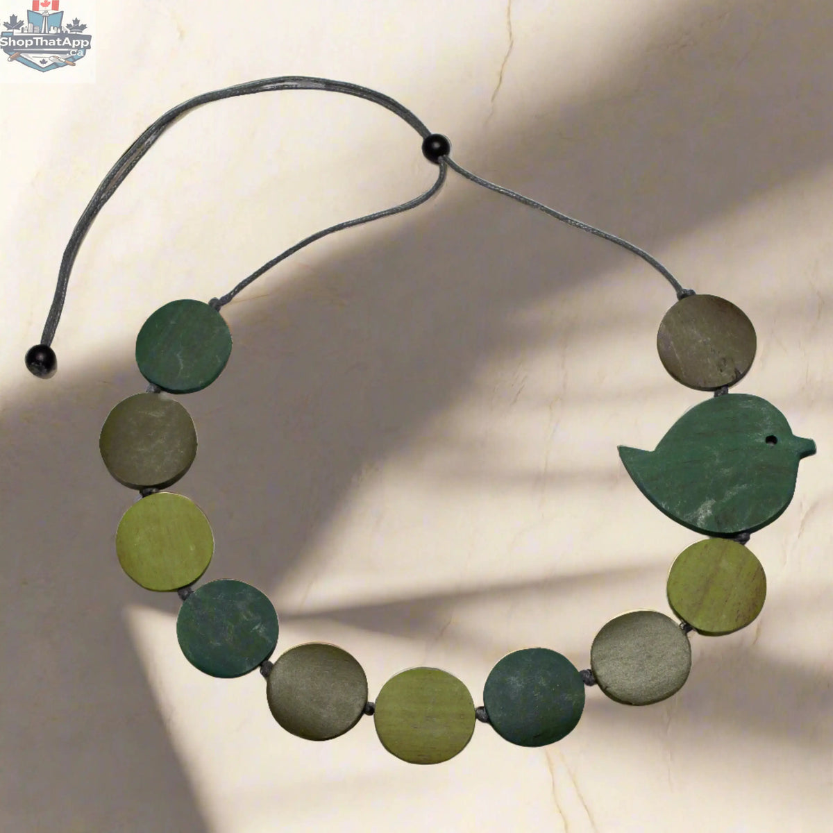 Fat bird necklace on wooden disc, nature-inspired jewelry by Suzie Blue Canada featuring a charming bird design.