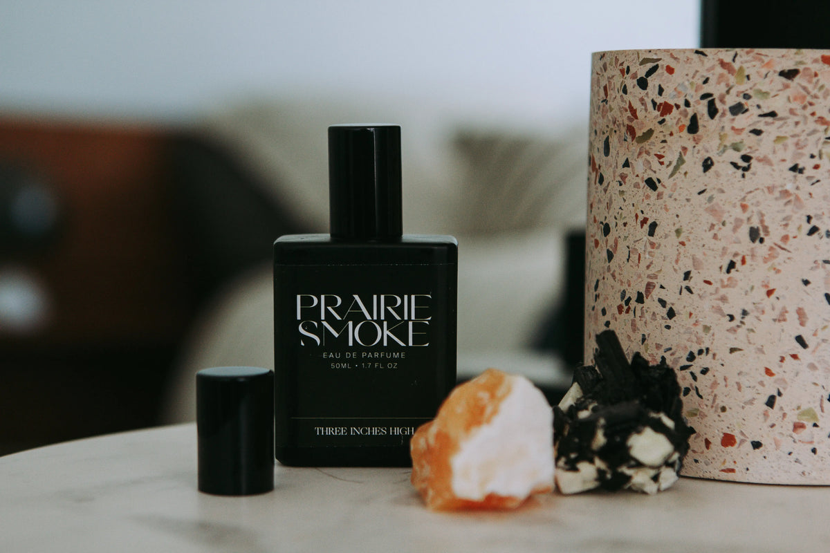 Three Inches High Prairie Smoke Eau de Parfum bottle with smoky, earthy fragrance, elegant design, and sophisticated branding.