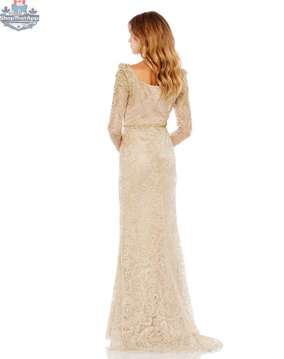Elegant gold embroidered appliqué trumpet evening gown with shoulder detail by Elegant Threads, showcased on a dress form.