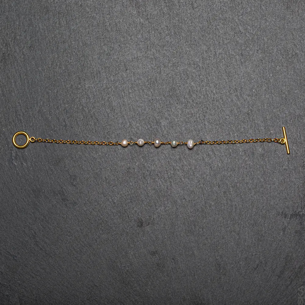 Gold-plated pearl bracelet with chain design, featuring delicate pearls and gold accents, by Suzie Blue Canada.