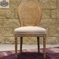 Hygge Design House Napoleon dining chair with antique linen upholstery and cane back, showcasing elegant woodworking and classic design
