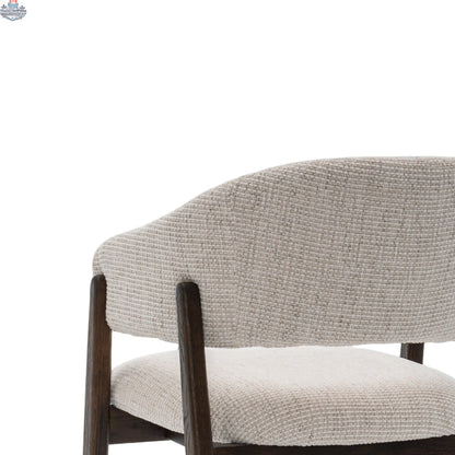 Fiol dining chair by Hygge Design House with beige upholstery and a dirty oak wood frame, shown from a side angle.