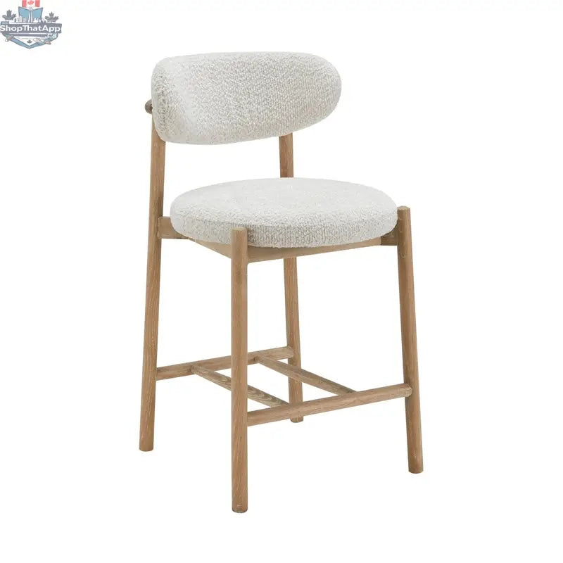 Hygge Design House Orazio counter stool with wooden legs and upholstered seat, shown in a modern interior setting.