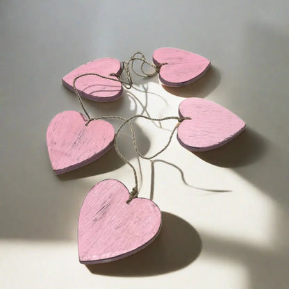 Set of five hanging wooden heart string decor by Suzie Blue Canada, featuring rustic wooden hearts for home decoration.