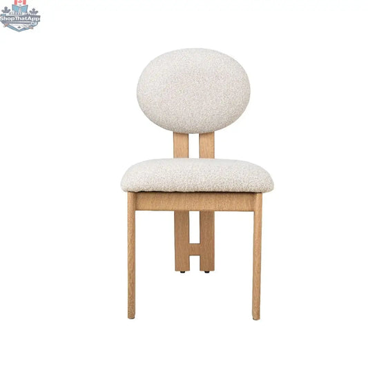 Hygge Design House Tova Dining Chair with wooden legs and upholstered seat, modern Scandinavian style, in a cozy dining room setting.