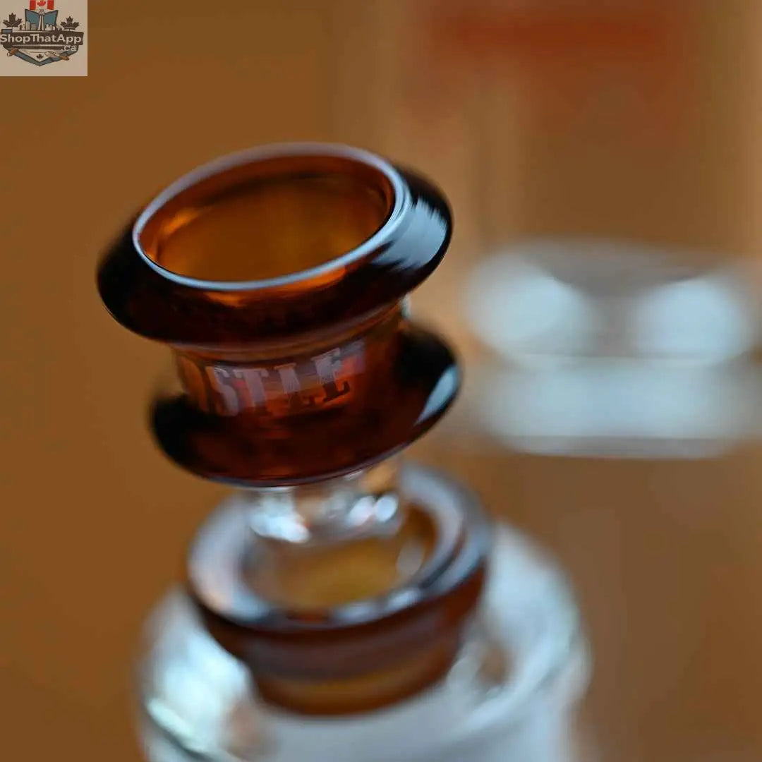 Castle Glassworks 14-inch amber beaker bong with colored logo and 9-hole downstem replacement, close-up shot showing bowl and design details.