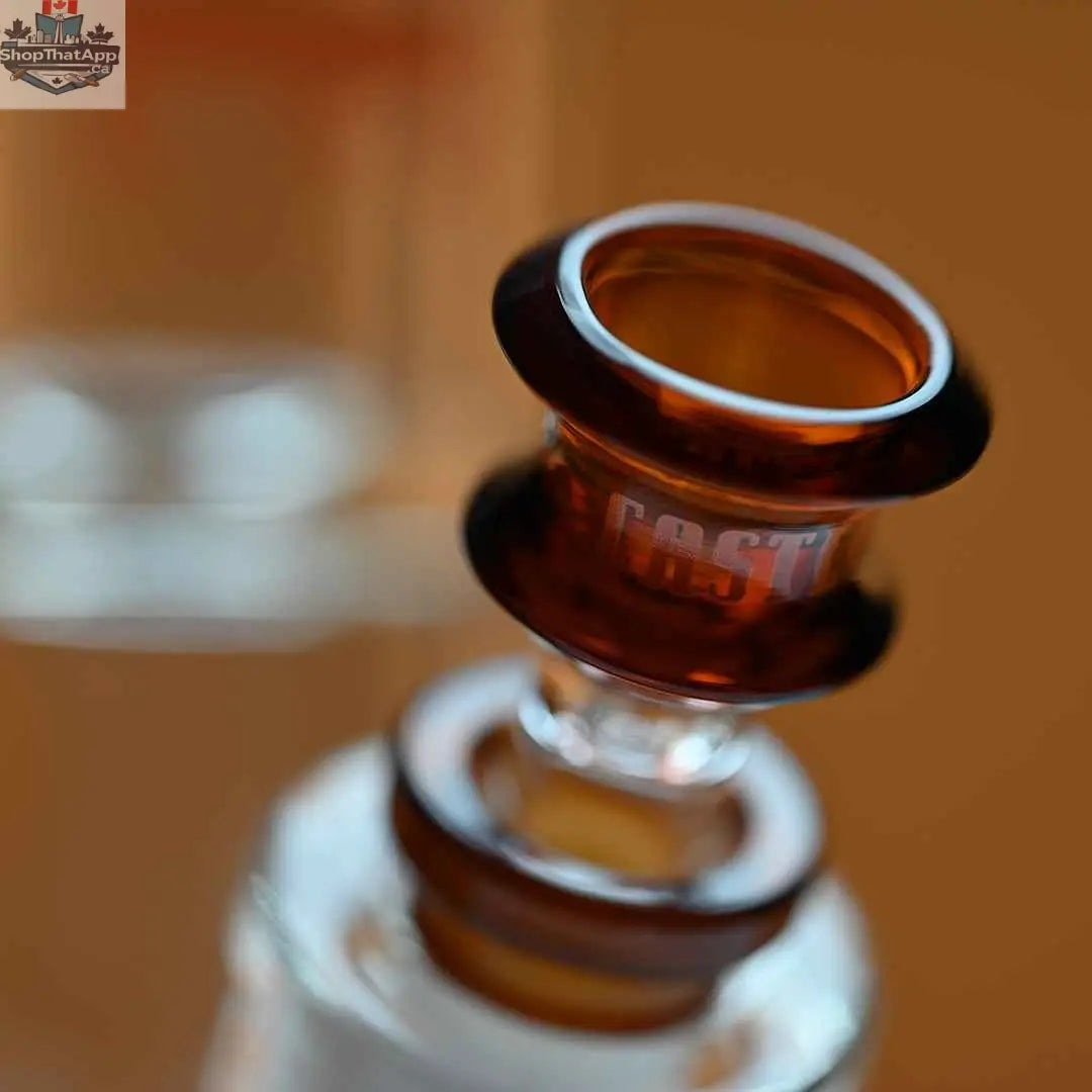 Castle Glassworks 14-inch beaker bong with amber logo, 9mm thickness, colorful logo, and 9-hole downstem replacement on amber background.