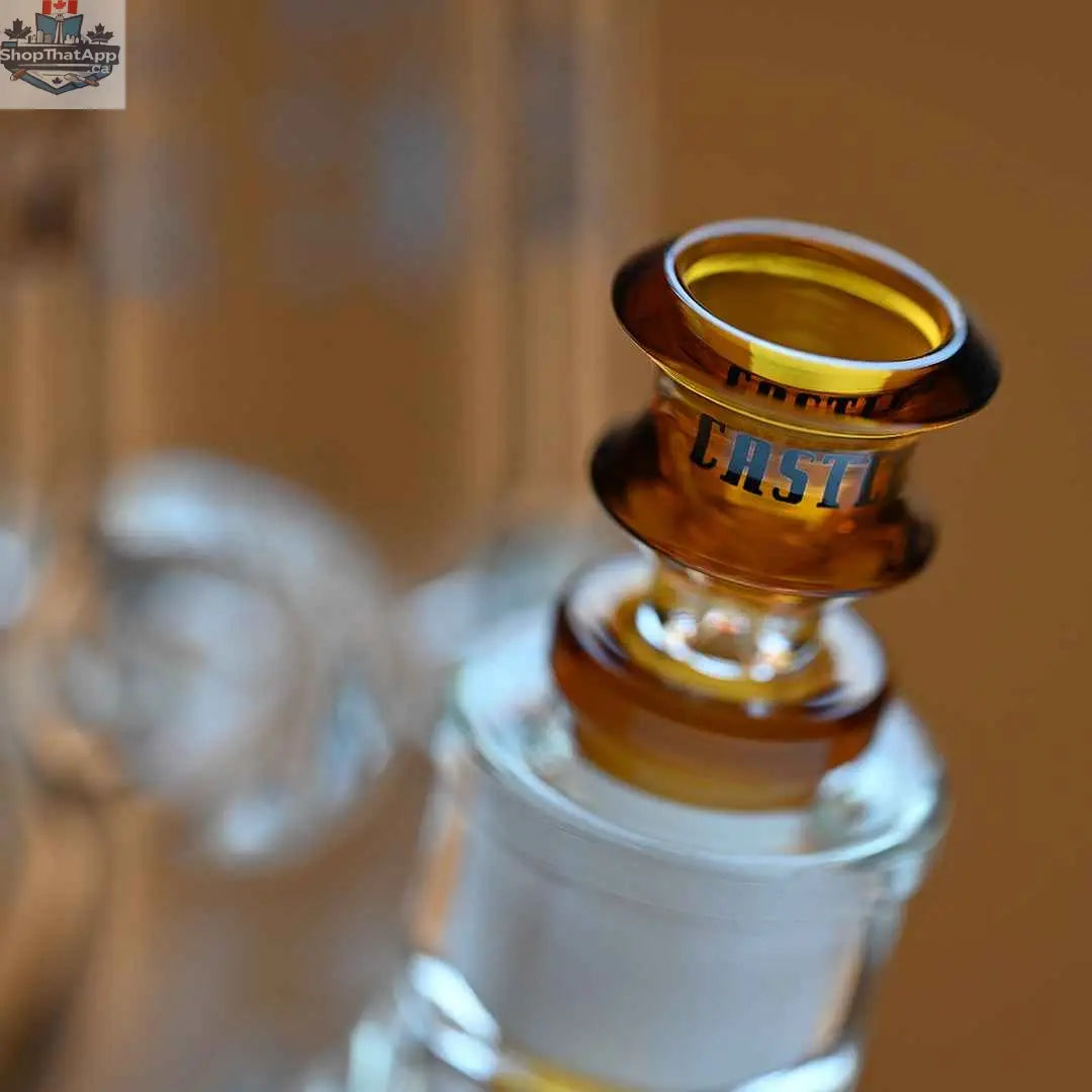 Close-up of Castle Glassworks 18-inch Anubis beaker bong with 9mm thick glass on an amber background, showing the detailed design.