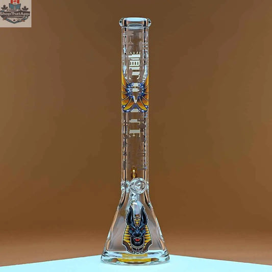 18-inch Castle Glassworks Anubis beaker bong with 9mm thick glass and detailed Anubis design on an amber background