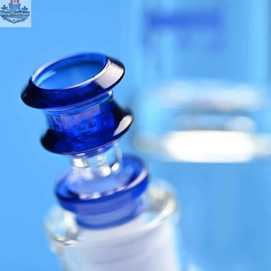Castle Glassworks 14-inch beaker bong with blue logo, 9mm thickness, and 9-hole downstem replacement on a blue background.