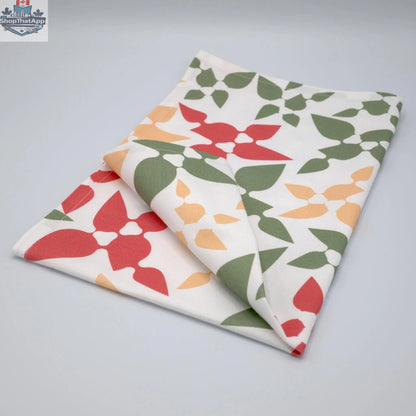 Pink printed cotton kitchen tea towel from Hem and Tassel's Celebration collection, neatly folded and showcasing festive design.