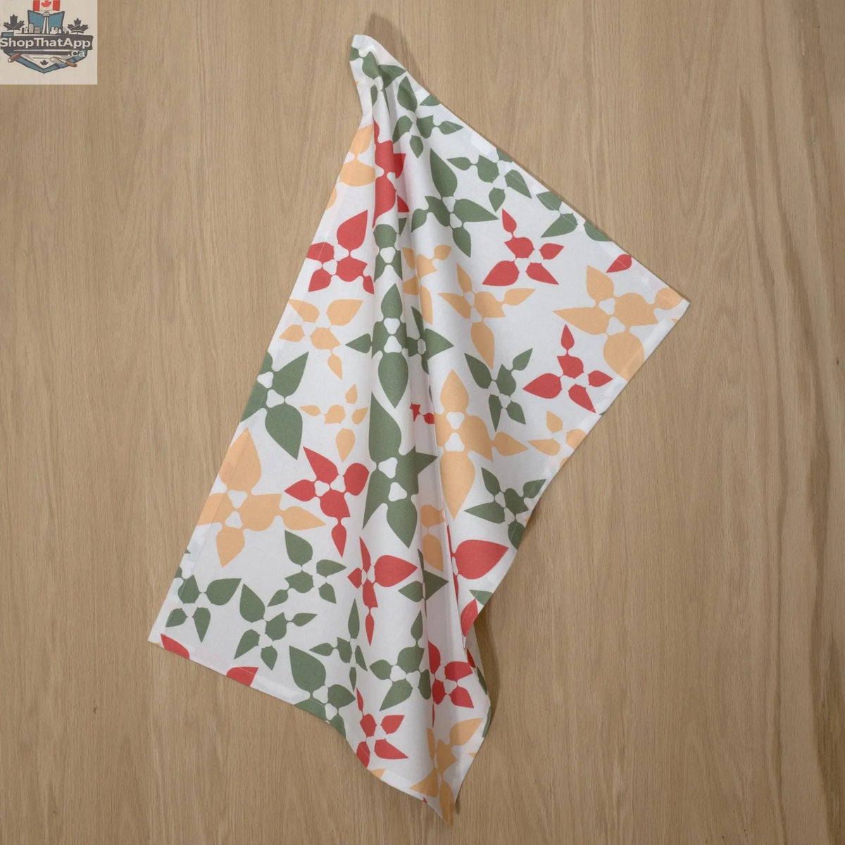 Pink printed Celebration Cotton Tea Towel by Hem And Tassel hanging on a hook, showcasing vibrant design for kitchen decor.