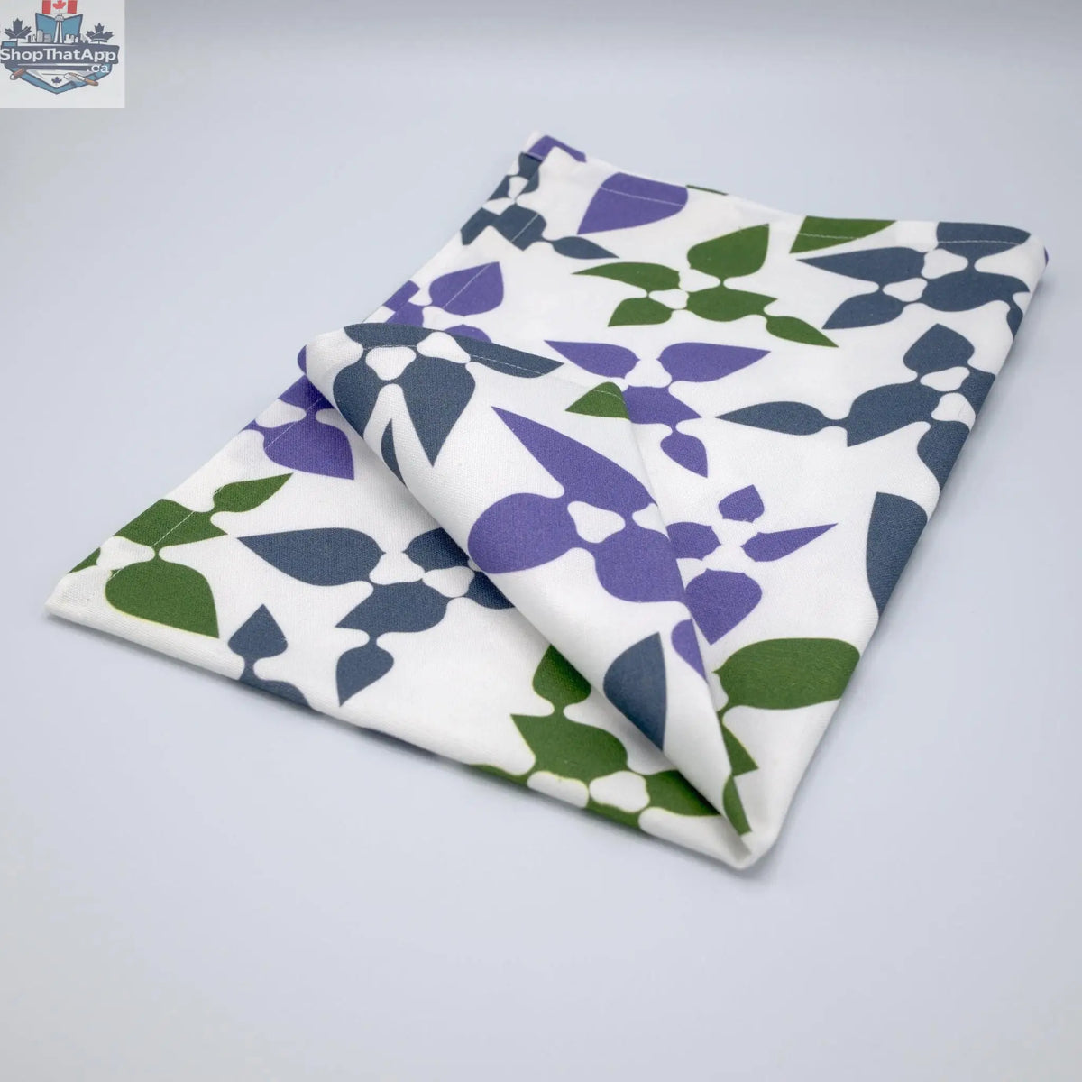 Purple printed cotton tea towel from Hem And Tassel's Celebration collection, folded to showcase floral and celebratory design.