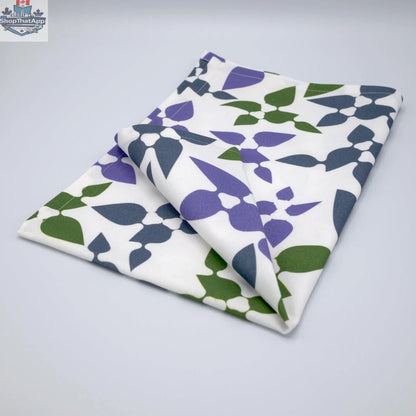 Purple printed cotton tea towel from Hem And Tassel's Celebration collection, folded to showcase floral and celebratory design.