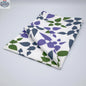 Purple printed cotton tea towel from Hem And Tassel's Celebration collection, folded to showcase floral and celebratory design.