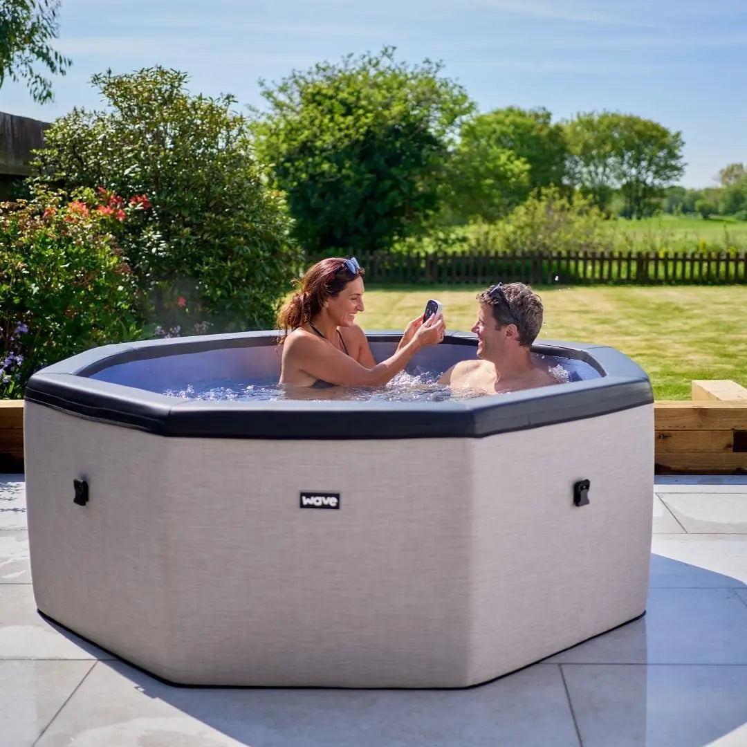 Zoppinh Wave Como 6-person eco foam hot tub with octagon shape and built-in integrated heater, shown with people relaxing inside.