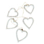 String of open wooden heart decorations hanging on a wall, perfect for home decor by Suzie Blue Canada.