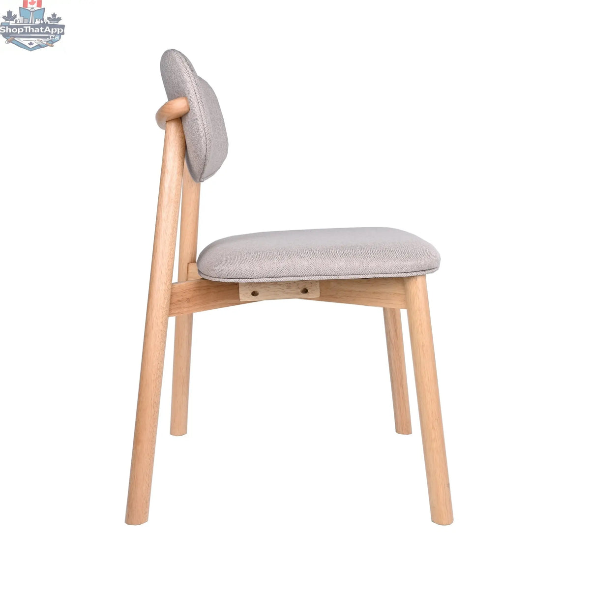 Hygge Design House Alva dining chair with wooden legs and upholstered seat, shown in a modern dining room setting.