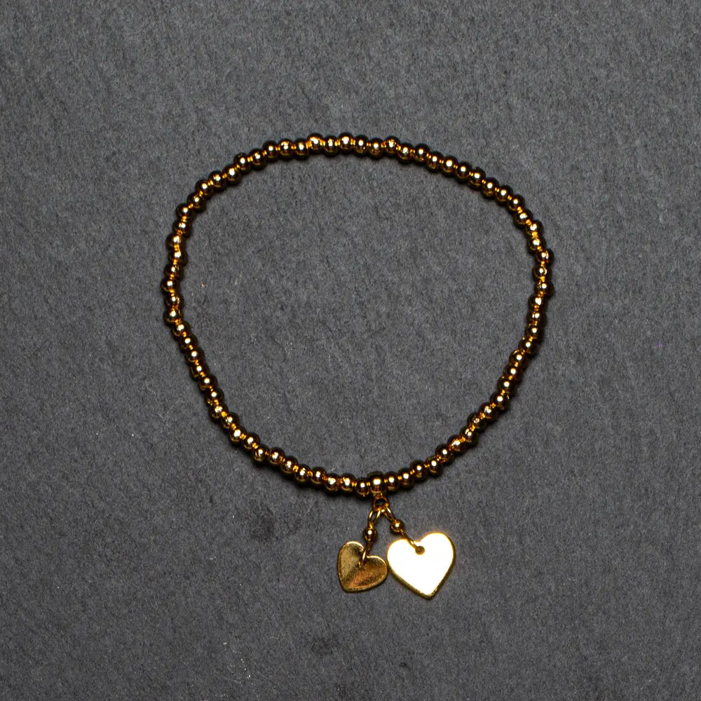 Gold heart charm bracelet in gold plate, featuring elasticated design, by Suzie Blue Canada.