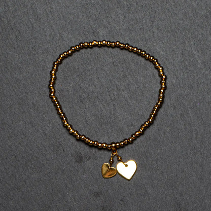 Gold heart charm bracelet in gold plate, featuring elasticated design, by Suzie Blue Canada.