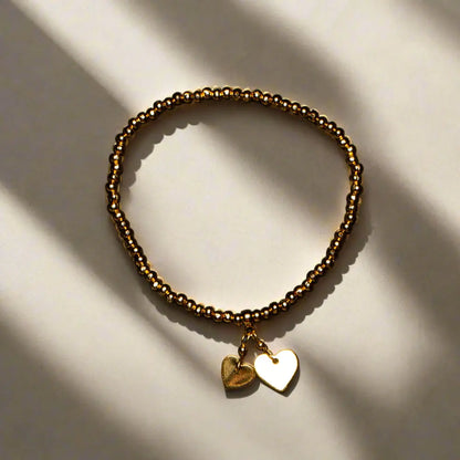 Gold heart charm bracelet with elasticated design, shiny gold plating, featuring delicate heart-shaped accents, by Suzie Blue Canada.