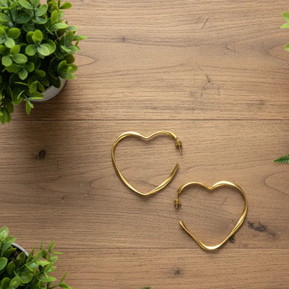 Large gold heart hoop earrings by Suzie Blue Canada featuring bold, statement jewelry design with heart-shaped hoops.