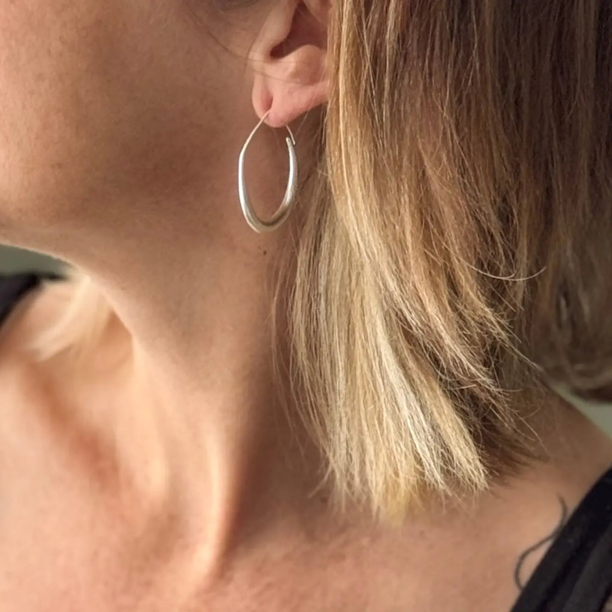 Silver teardrop hoop earring by Suzie Blue Canada featuring a sleek, elegant design in polished silver plating.