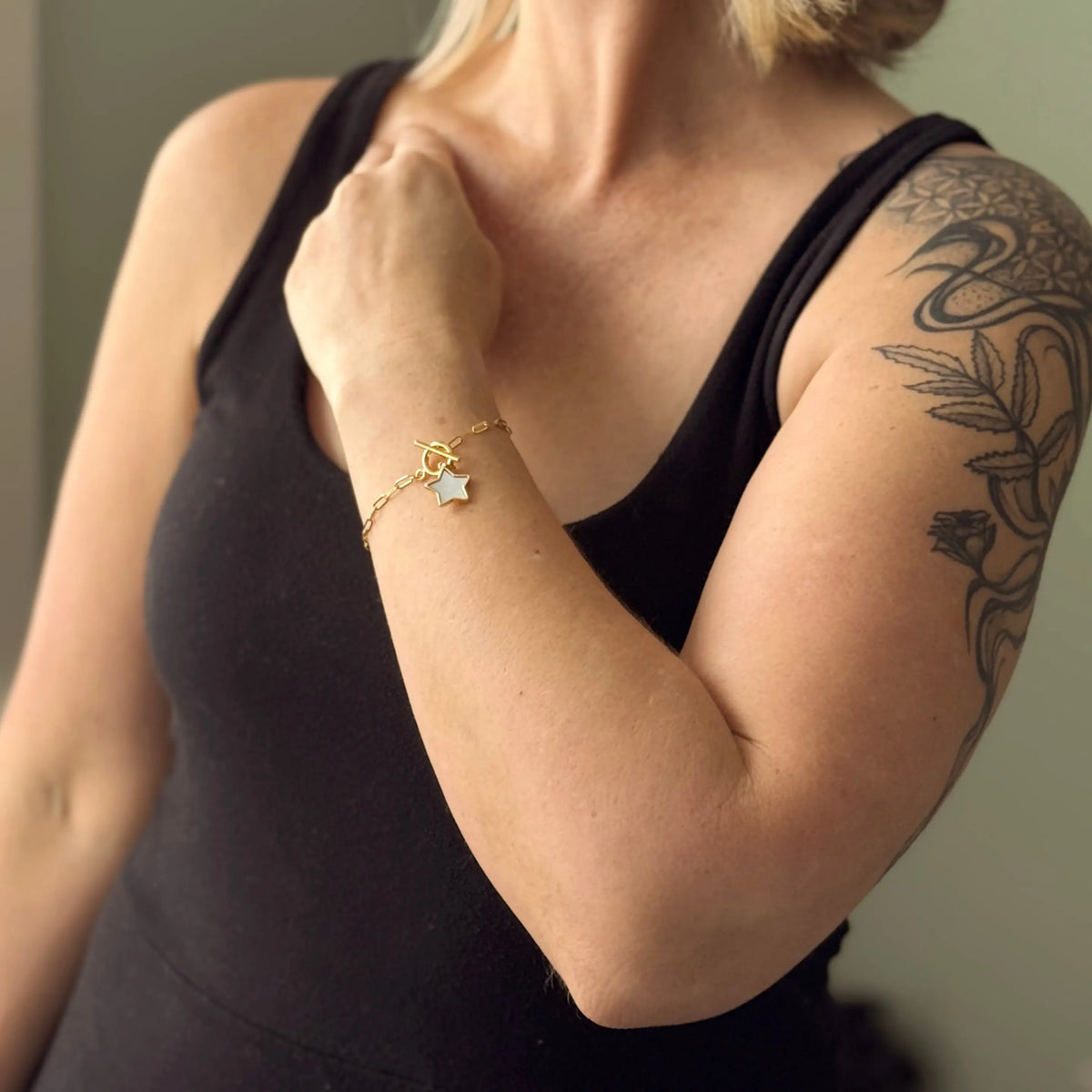Suzie Blue Canada chainlink bracelet featuring a mother of pearl charm and silver-toned links on a white background.