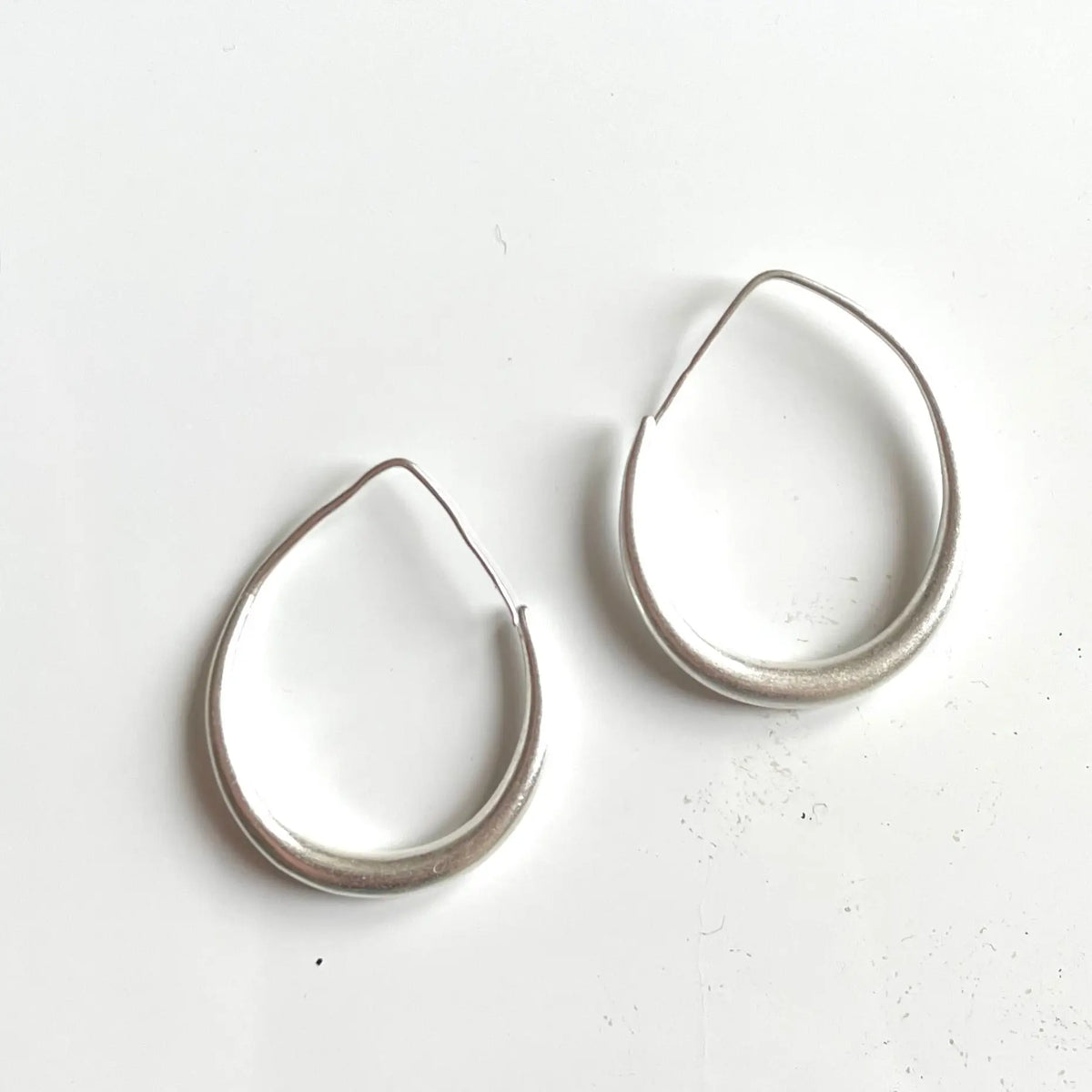 Silver plate teardrop hoop earrings by Suzie Blue Canada, featuring an elegant and stylish jewelry design.
