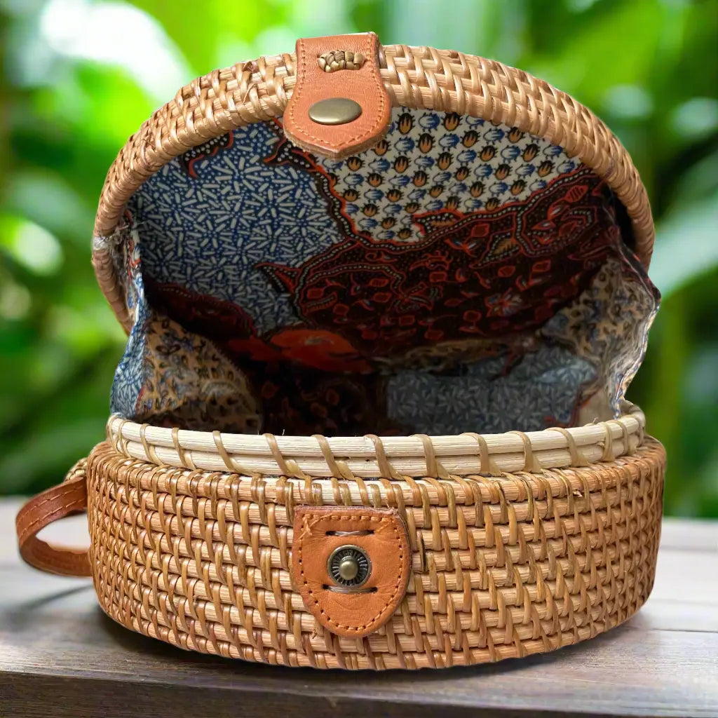 Black round rattan purse by Suzie Blue Canada with a woven handle and compact, stylish design for elegant accessories.