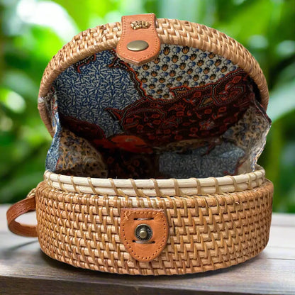 Black round rattan purse by Suzie Blue Canada with a woven handle and compact, stylish design for elegant accessories.