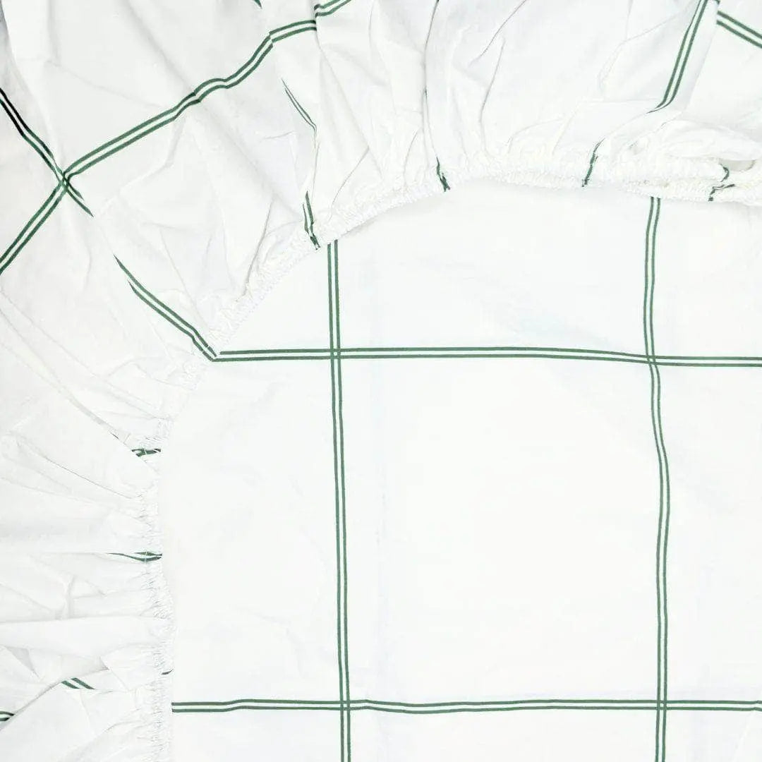 Organic percale fitted sheet from Skylark+Owl Canada with leaf pattern, showing corner detail for a comfortable sleep experience.