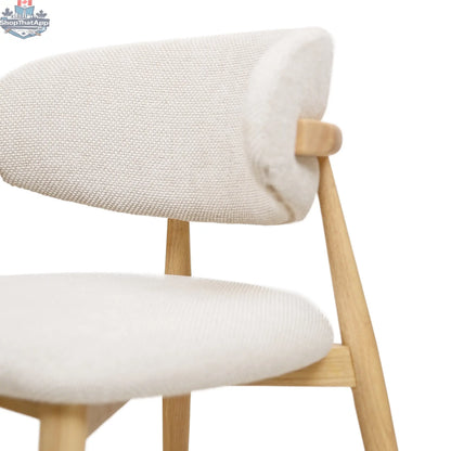 Nero Vogar dining chair by Hygge Design House with modern wooden frame and upholstered seat, shown in a contemporary dining setting.