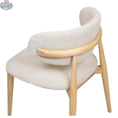 Nero Vogar dining chair by Hygge Design House with wooden legs and a curved upholstered seat in a modern design.
