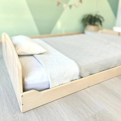 Sapiens Child cherry twin Montessori floor bed with built-in shelves for kids' bedroom, featuring a low, accessible design for toddlers.