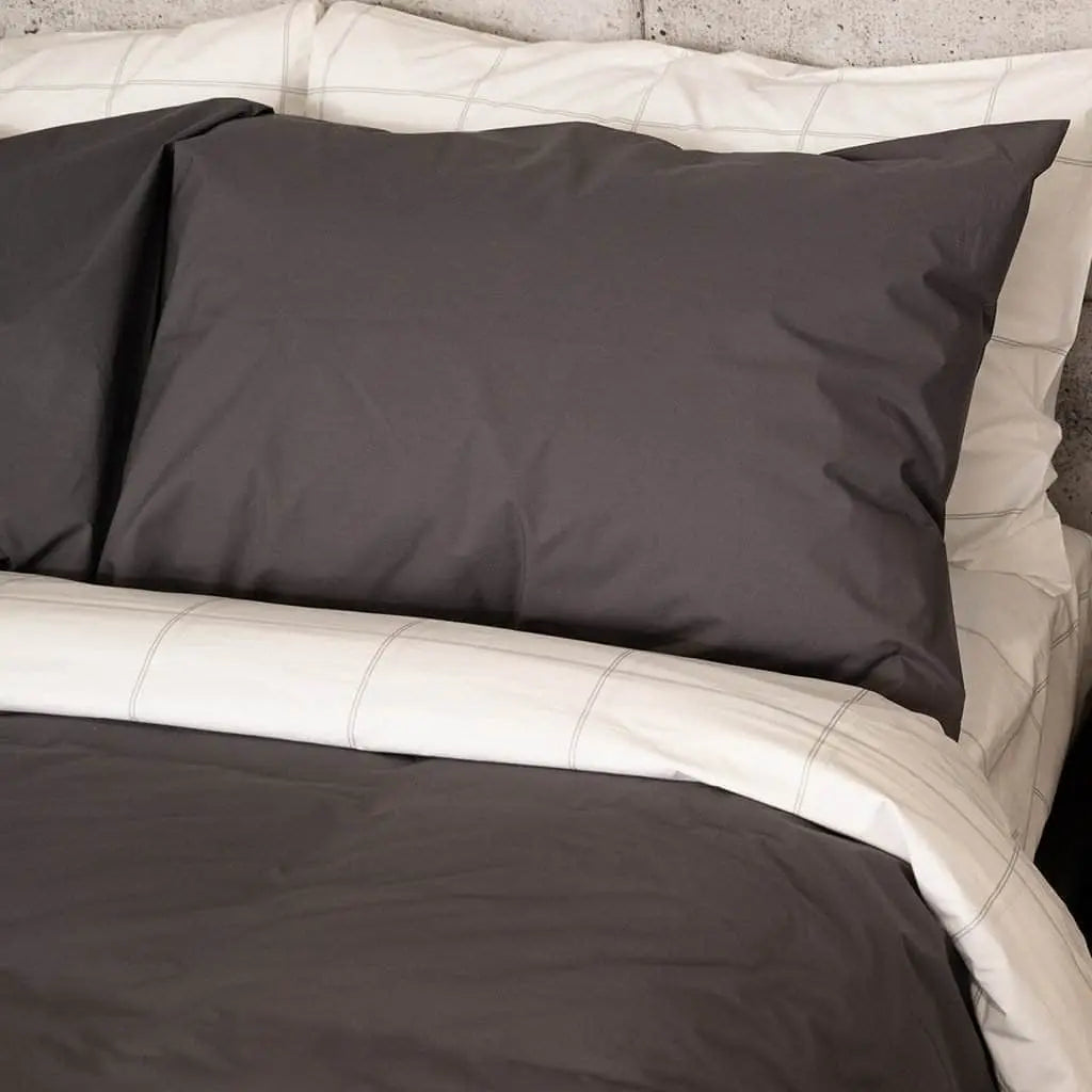 Charcoal-colored organic percale sheets from Skylark+Owl Canada, featuring a luxurious, crisp sheet set with smooth, breathable fabric.