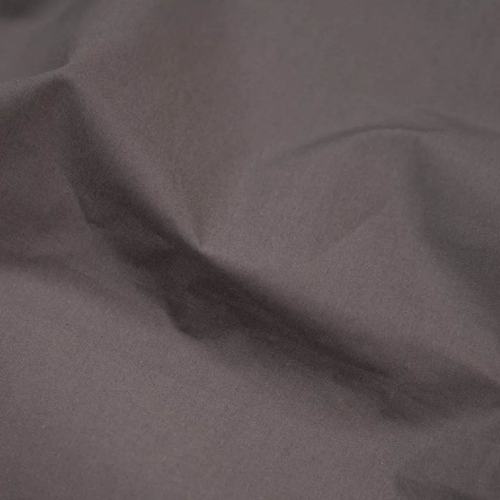 Charcoal organic percale sheets from Skylark+Owl Canada, showcasing a luxurious, crisp sheet set with neatly folded sheets.
