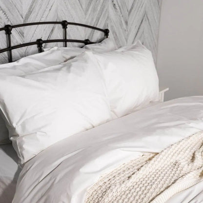 White organic percale pillowcase set by Skylark+Owl Canada, showing smooth, crisp fabric with neatly sewn edges for luxurious sleep.