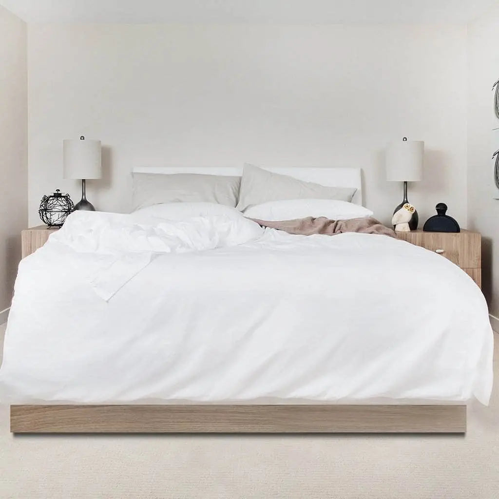 White Skylark+Owl Canada refined sateen sheet set with smooth, luxurious fabric laid out on a bed for bedroom comfort.