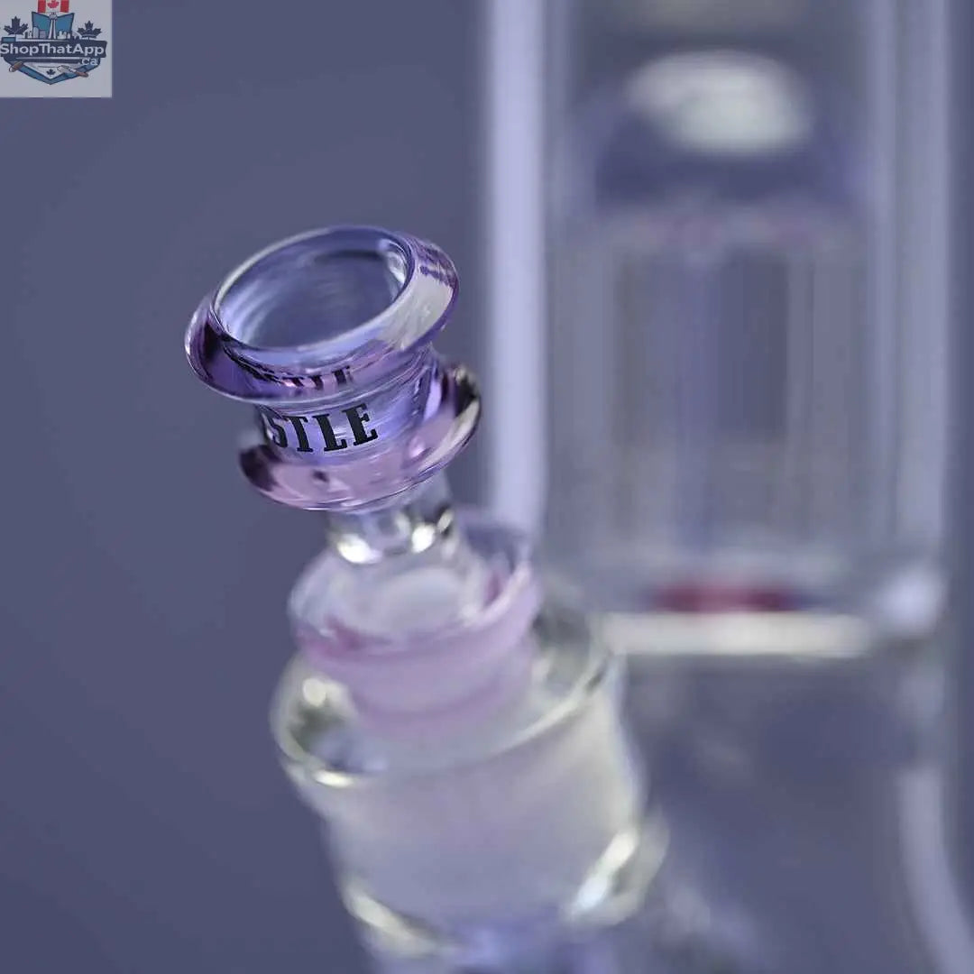Close-up of a purple 8-arm beaker bong by Castle Glassworks with a purple background and a clear bowl attachment.
