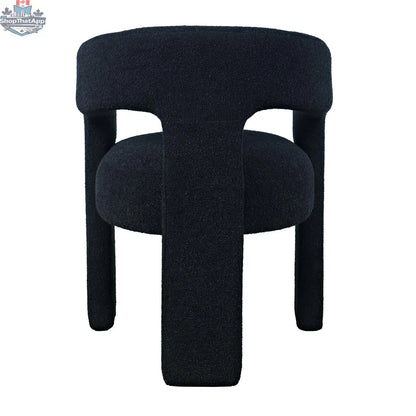 Sven upholstered dining chair in black bouclé fabric with wooden legs, shown from the back, by Hygge Design House.