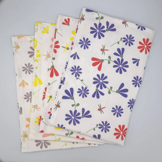 Stacked and fanned Hem And Tassel Shy Dragonfly printed kitchen tea towels showcasing colorful dragonfly designs.