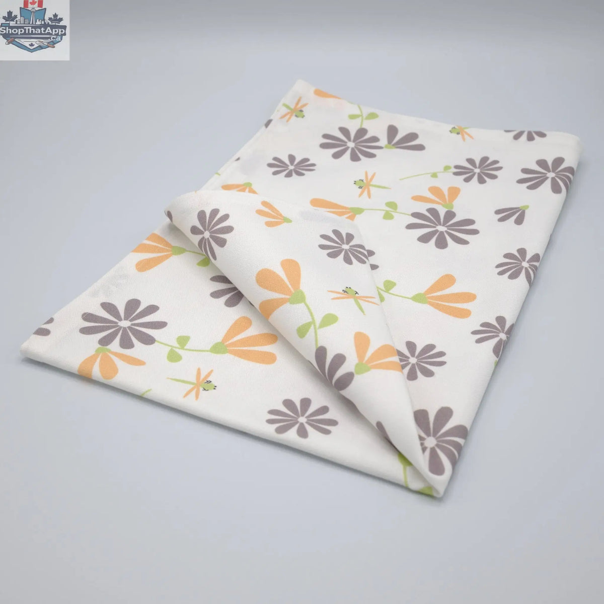Gray and buff printed kitchen tea towels featuring a shy dragonfly design from Hem And Tassel, folded neatly.