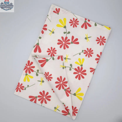 Pink and yellow printed Shy Dragonfly tea towel from Hem And Tassel, folded to showcase colorful dragonfly design.